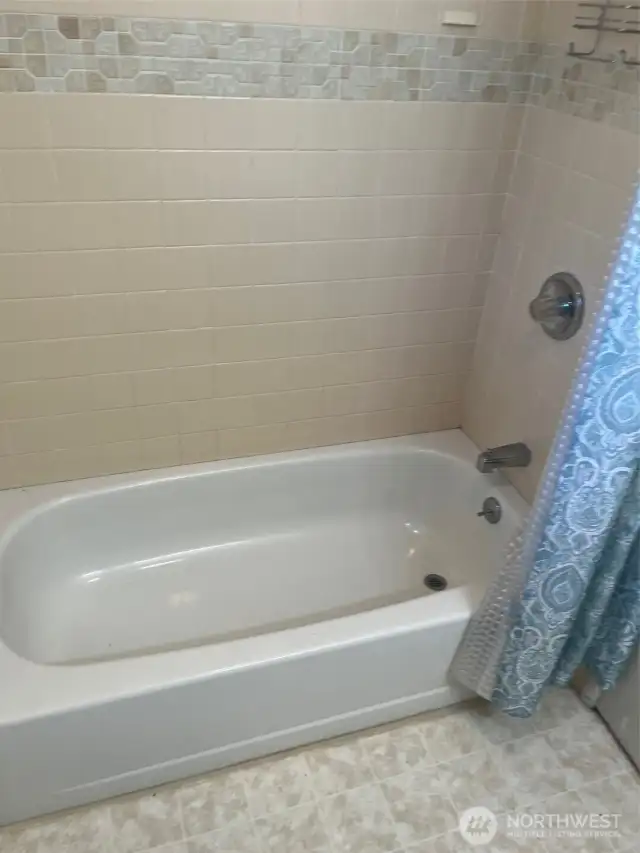 Soaking tube with Tile above in full bathroom near bedrooms.