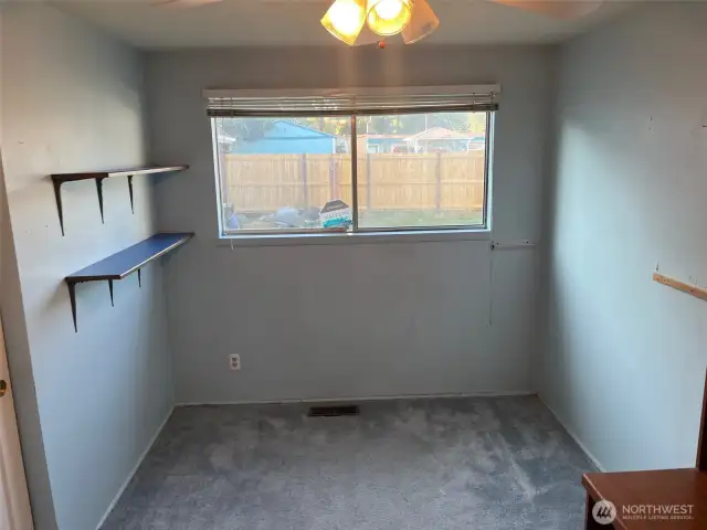 5th Bedroom at North end of House. Has blue carpet, and looks out to back yard.