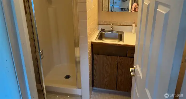 Guest 3/4 bathroom in breezeway between formal Dining room and Living room, with shower toilet sink, medicine cabinet 3 pane vanity and cabinets for storage.