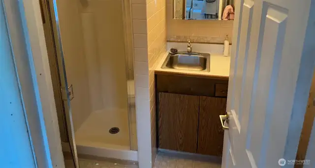 Guest 3/4 bathroom in breezeway between formal Dining room and Living room, with shower toilet sink, medicine cabinet 3 pane vanity and cabinets for storage.