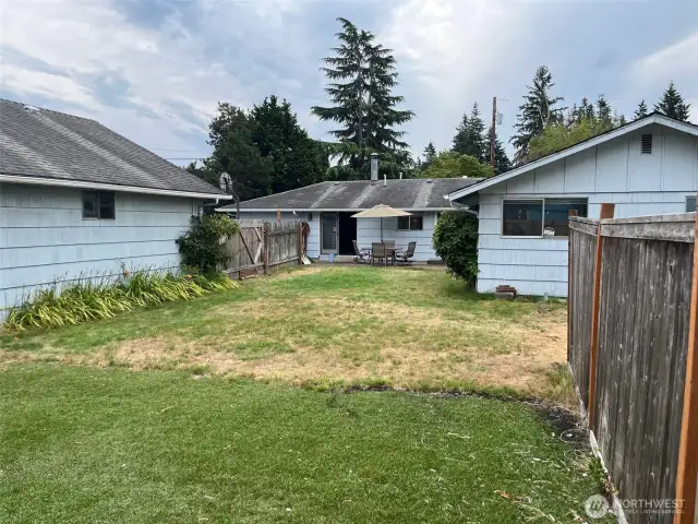 View of Backyard, North side of house, patio, rear entrance,  West side of shop from the Back Fence.