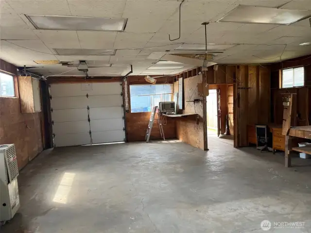 Front of Shop/Garage with garage Door and entry door. Lots of room for parking or shop activities. Notice Attic stairway near entrance that leads to lots of storage above.