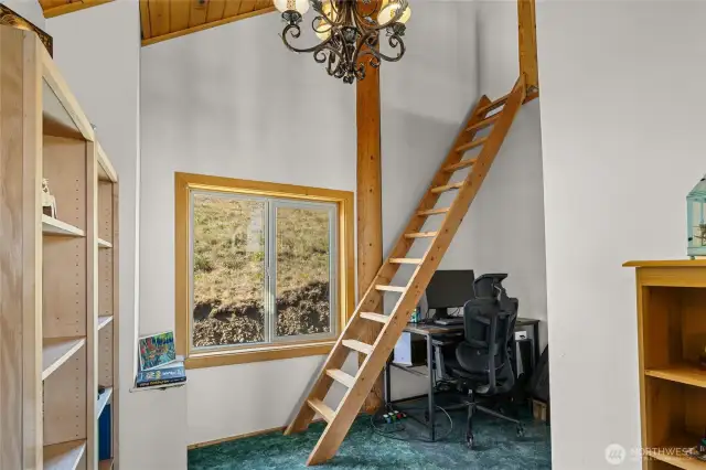 Little nook used for an office area and stairs leading to a loft.