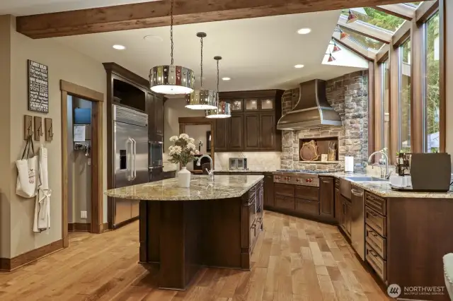 Live-edge slab granite counters and espresso-stained distressed wood cabinetry.