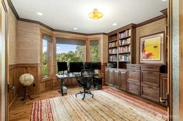 Large study or office off the foyer with rain glass French doors, bat and board wainscoting and hardwood floors.