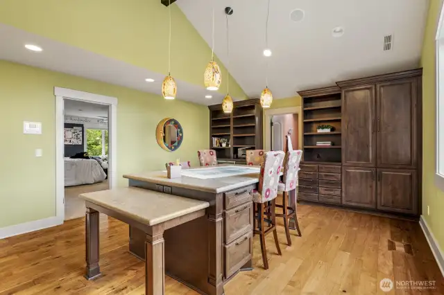 A versatile bonus space with a slab granite work table, built-in cabinetry, and beverage fridge—ideal as a study nook or creative workspace.