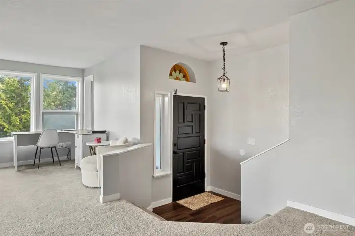 Bright entry with a stylish black front door, updated light fixture, and a unique stained-glass accent window. The space opens into a versatile layout with abundant natural light.