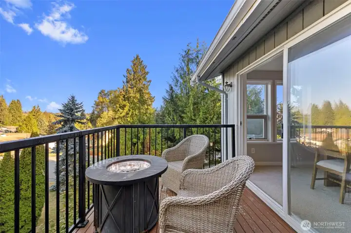 A spacious deck overlooks lush greenery and offers an ideal spot for outdoor dining, barbecues, or morning coffee in a tranquil setting.