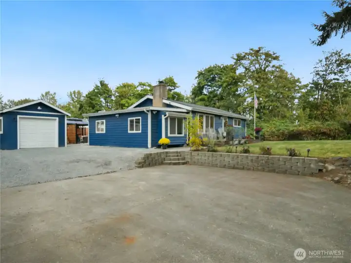 Spacious driveway with detached garage and well-kept exterior.