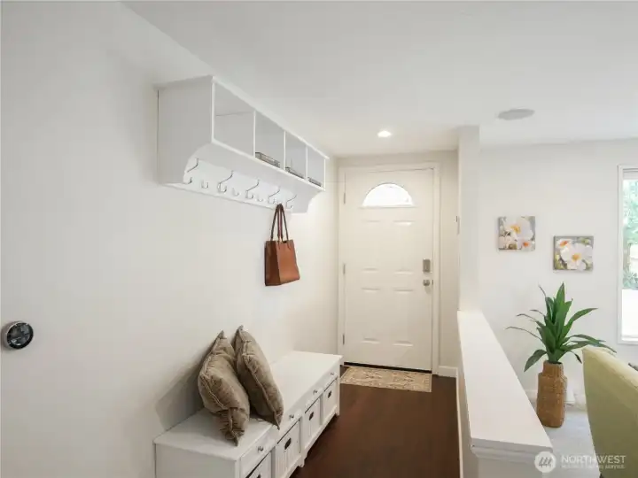 Bright entry with hardwood floors and stylish storage.