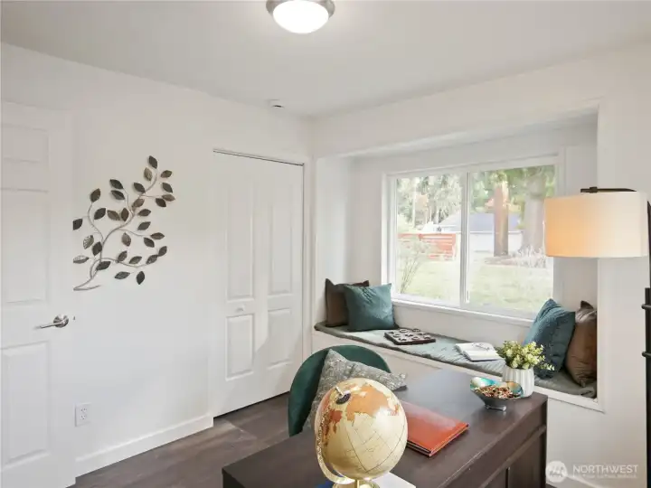 Cozy built-in window seat with plush cushions and decorative wall art—ideal for reading, relaxing, or daydreaming.