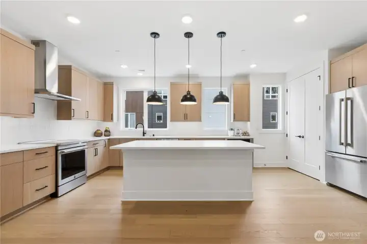 Gourmet kitchen featuring SS appliances, gorgeous kitchen island and dramatic pendant lighting.