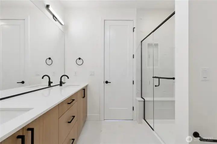 Dual vanities and ample storage with designer cabinetry in the primary bath.
