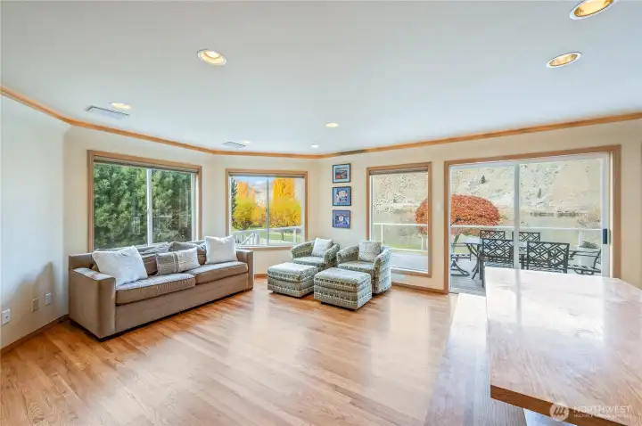 Open main-level living area with hardwood floors and large windows framing river and territorial views.