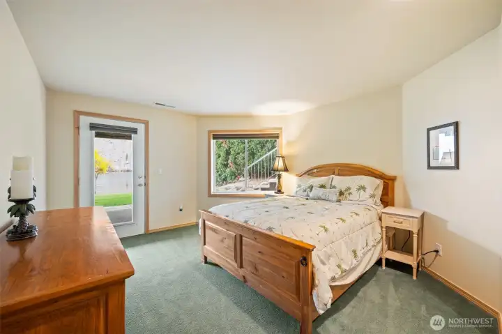 Lower-level bedroom with direct walkout access to the lawn and riverfront area, ideal for guests or multi-generational living.