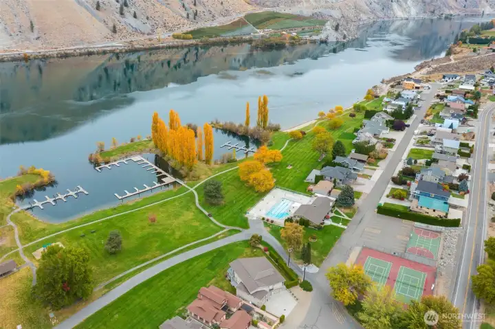 Bird’s-eye view of Sun Cove’s outdoor pool, clubhouse, tennis and pickleball courts, and manicured common areas.