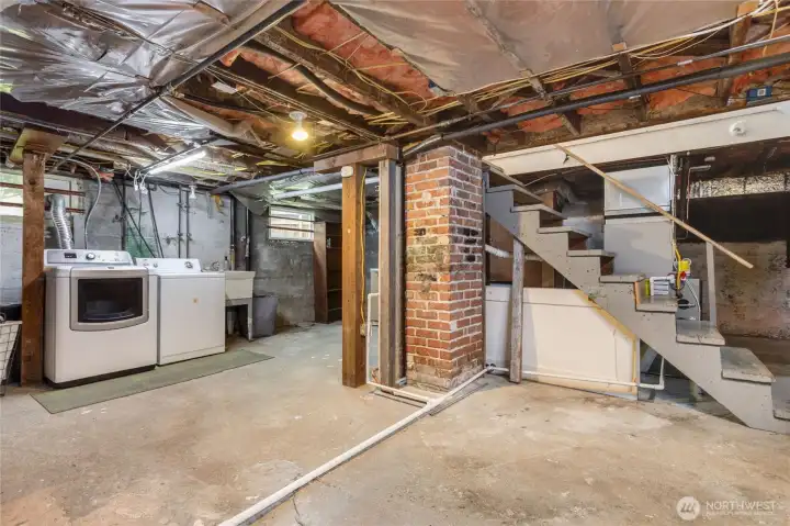 unfinished basement with included washer and dryer, sink and lots of storage.