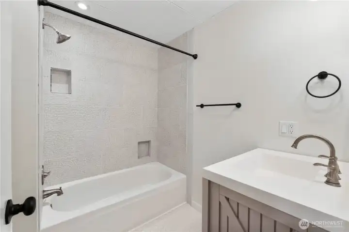 Full guest bath with tiled shower/tub combo.