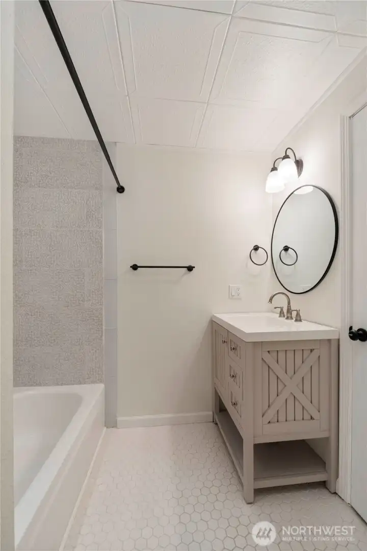 Another view of the guest bath showing the chic tile flooring and vanity.