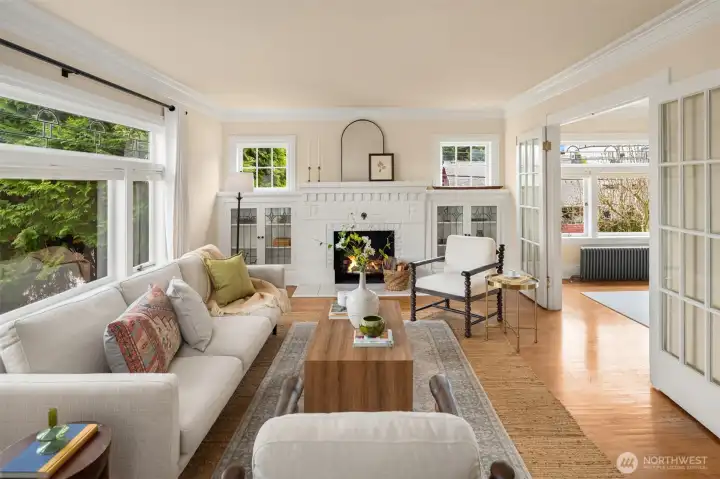 Leaded-glass built-ins are featured on either side of the wood-burning fireplace. Glass-pane French doors frame the traditional living and dining rooms.
