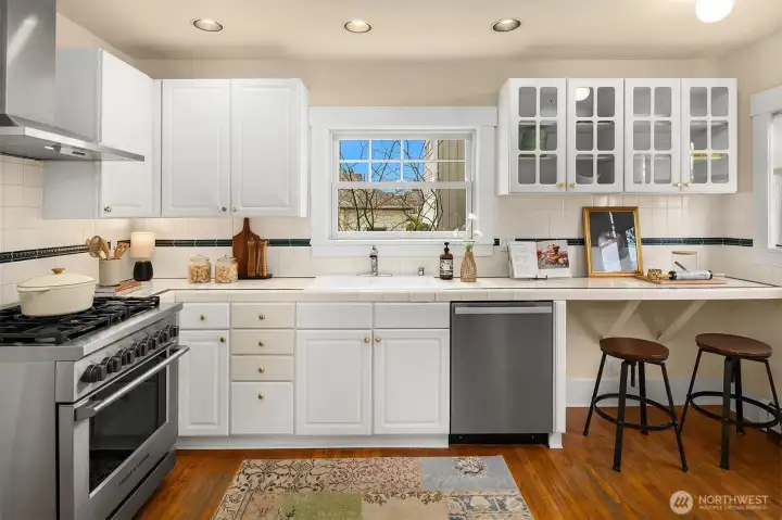 The kitchen balances timeless charm with thoughtful updates, featuring a five-burner Fisher & Paykel gas range, Miele dishwasher, and bar seating.