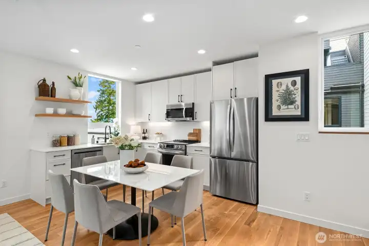 The kitchen features quartz counters, SS appliances, custom cabinets, stylish backsplash and under-cabinet lighting.