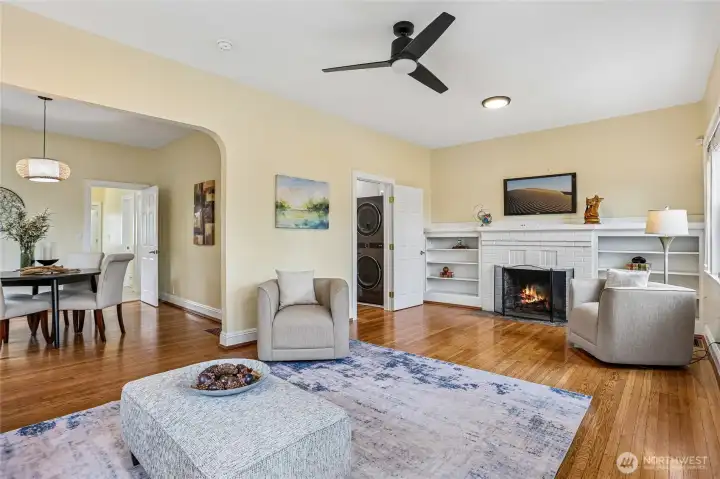Living room off of entry with original hardwood floors, wood burning fireplace and built in bookcase.