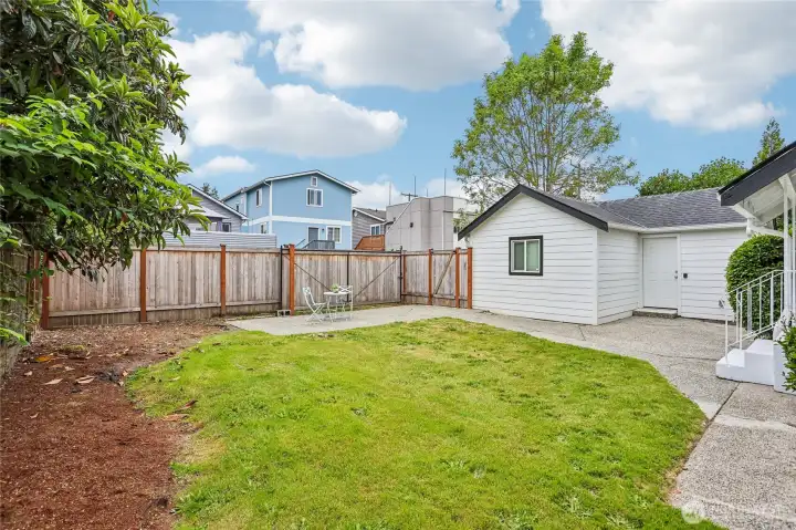 Another view of the backyard with possible trailer or boat parking and the detached garage and storage area.