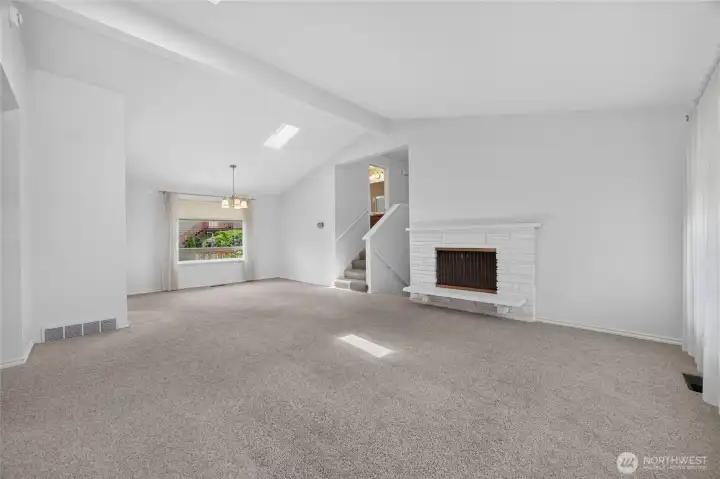 Open living and dining room with fireplace. Hardwoods under carpeting Open living and dining room with fireplace. Hardwoods under carpeting