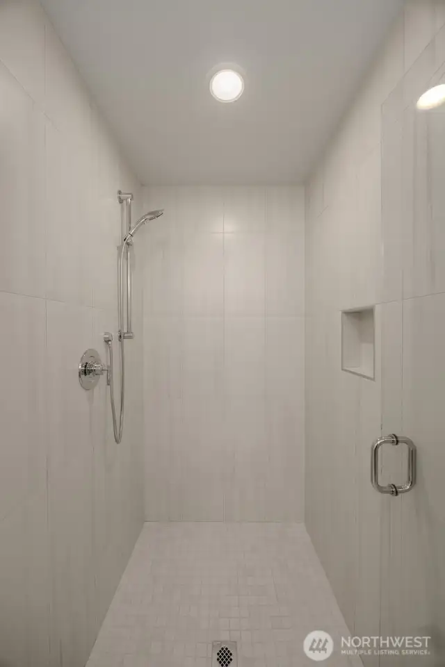 Refresh in the glass-enclosed shower lined with elegant, oversized tile.