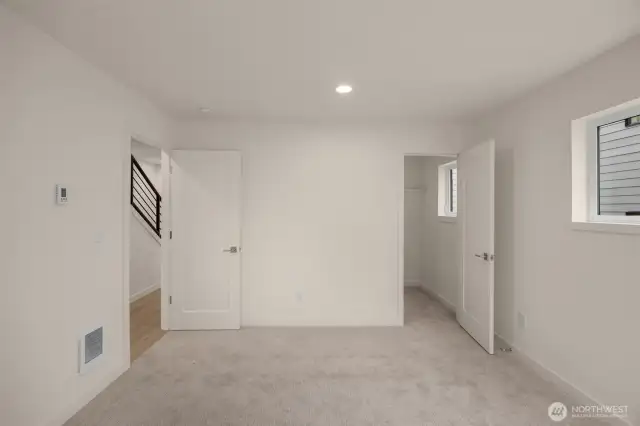 The lower-level bedroom with a walk-in closet offers flexibility as a guest suite, gym, or additional office space.