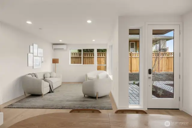 This image is virtually staged. Bright and open, the main level flows effortlessly from the kitchen to the living area and out to your front door—perfect for indoor-outdoor living.