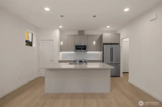 A chef’s dream! This expansive kitchen features a quartz-topped island, sleek cabinetry, and premium appliances ready to elevate your meals.