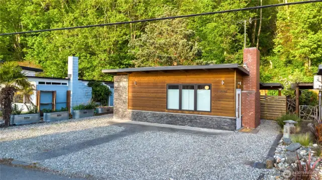 This cute beach bungalow backs a gorgeous treed hillside.