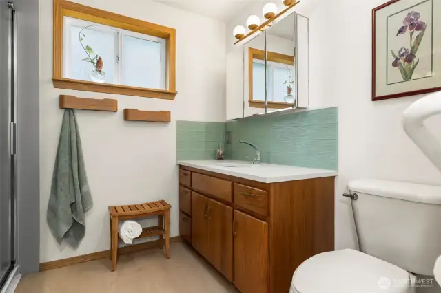 3/4 bath with quartz countertop and glass tile