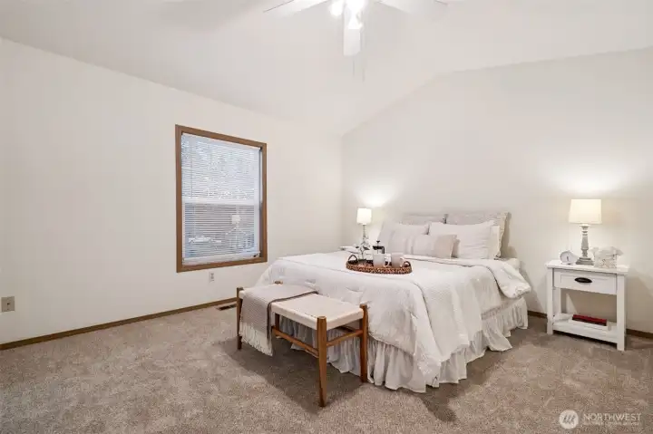 Primary bedroom with vaulted ceiling.