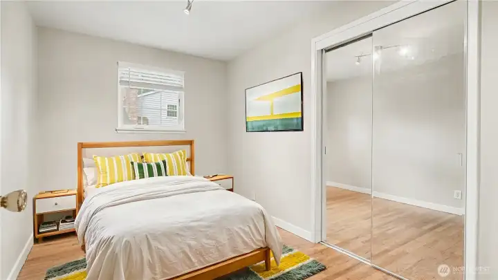 First guest bedroom offering neutral paint color and mirror closet doors. *Virtually staged*