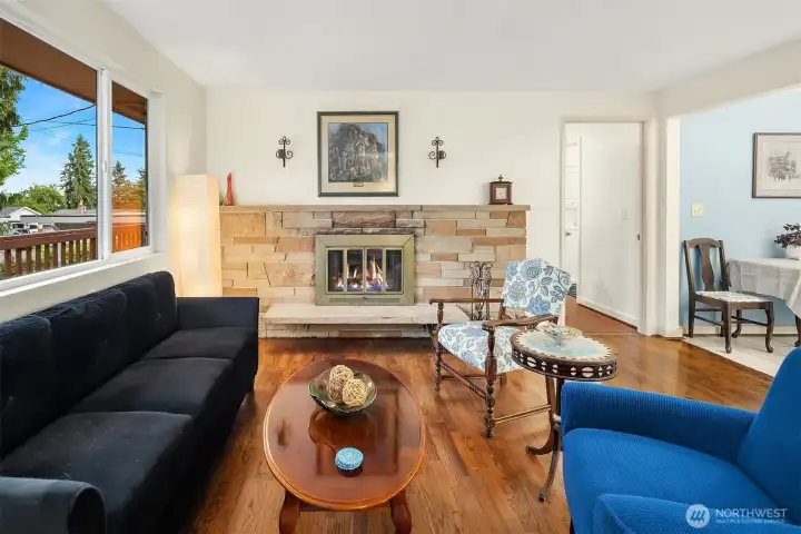 Inviting living room with original hardwoods and cozy wood burning fireplace