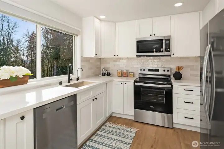 Roomy remodeled kitchen with ample cabinets, stainless steel appliances, and a high-end water filtration system.
