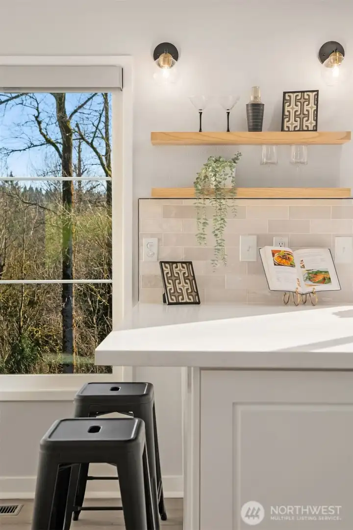 Remodeled kitchen with designer details including modern lighting and floating shelves.