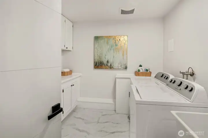 Large, dedicated laundry room with handy utility sink and extra storage.
