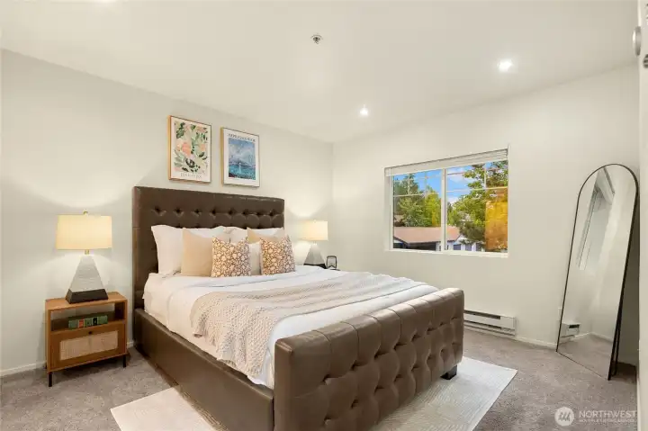 Spacious primary bedroom with morning sunlight.