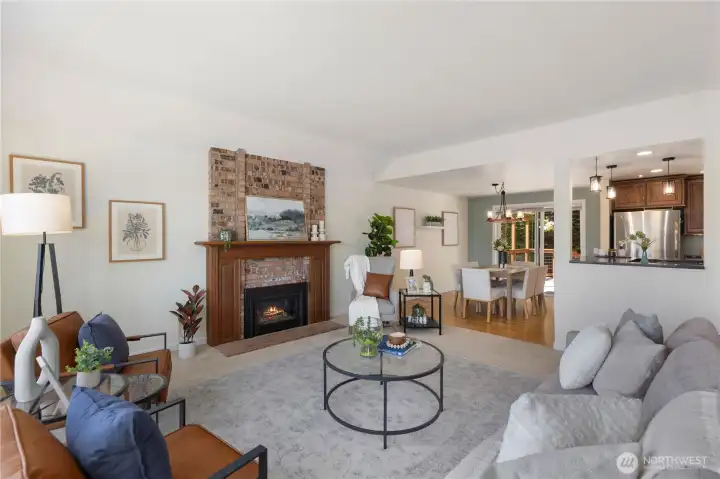 The brick fireplace with wood-trimmed surround serves as a stunning focal point, with the open sightline flowing naturally into the dining room and kitchen, ideal for everyday living and entertaining.