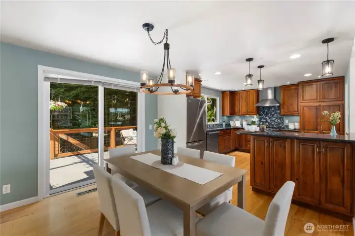 The dining space connects directly to the back deck through sliding glass doors, letting in abundant natural light and creating an effortless indoor-outdoor flow perfect for entertaining.
