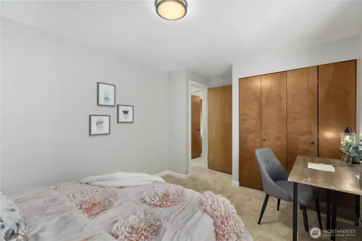 A second angle reveals the full bifold closet and a dedicated desk area, making this room equally suited as a bedroom or home office.