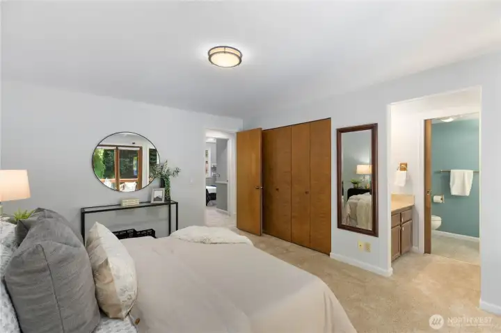 This primary suite showcases a full-width bifold closet and an en suite bathroom, a well-appointed and practical layout.