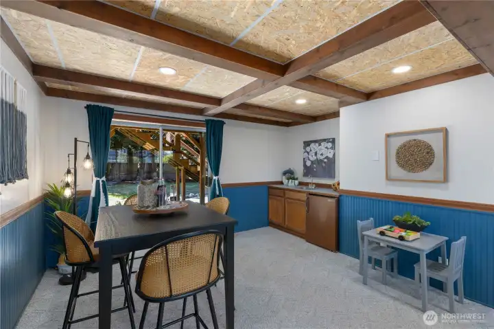 The lower level’s wet bar with cabinetry and sink sits alongside a dining area and sliding door to the backyard, a setup well-suited for entertaining or casual everyday use.
