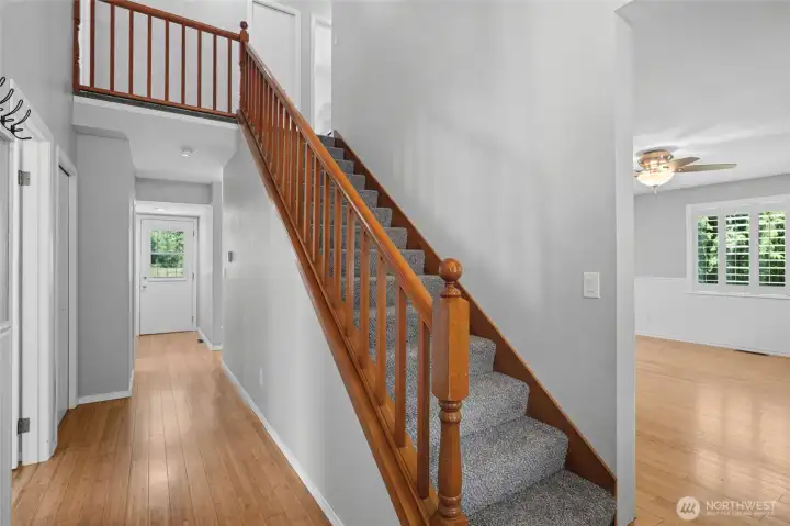 From the entryway with the primary bedroom on the left, living room on the right, Kitchen, dining, laundry and half bathroom straight ahead