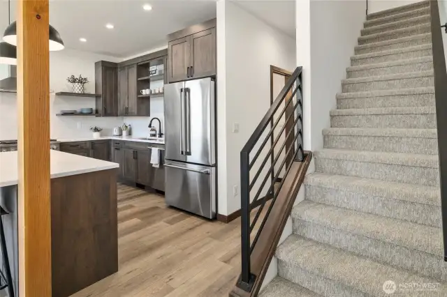 Stairs leading to the upper level which features 2 bedrooms, a shared bath, and a large linen closet.