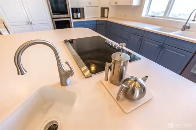 The oversized island features a wet bar and cooktop